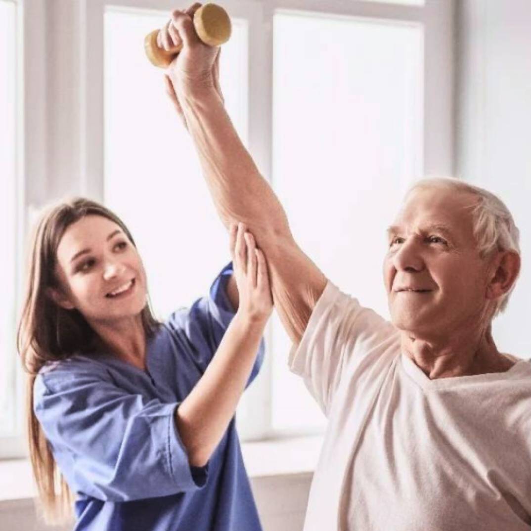 A healthcare worker and an elderly patient doing strength training